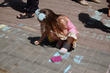 Малыши рисуют на асфальте цветными мелками