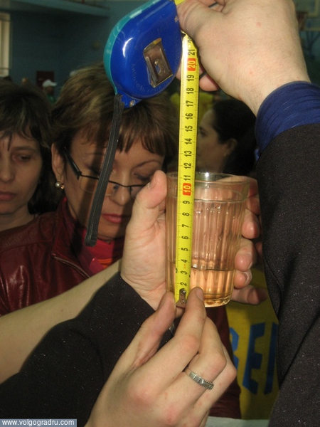 Судьи измеряют количество воды в стакане. день здоровья, соревнования, эстафеты