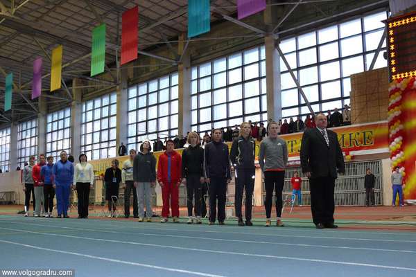 Участницы соревнований по прыжкам в длину (справа) и толканию ядра (слева) во время исполнения государственного гимна.. 